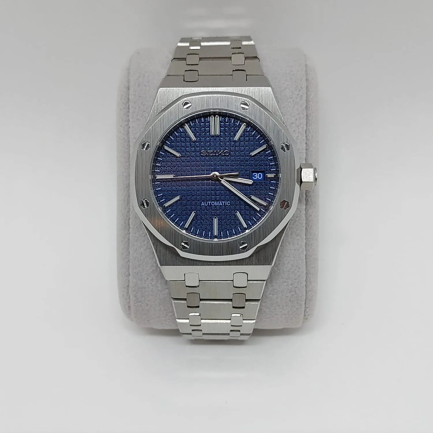 Stainless steel 41mm watch with navy blue textured dial, silver hour markers, date window, and linked bracelet.