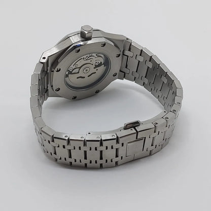 Seiko NH35 wristwatch with stainless steel bracelet, open case back showing automatic movement, and navy blue dial glimpse.