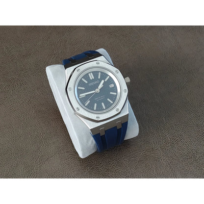 Seiko NH35 Royal Oak watch with navy blue dial, silver octagonal bezel, and blue rubber strap on white cushion.