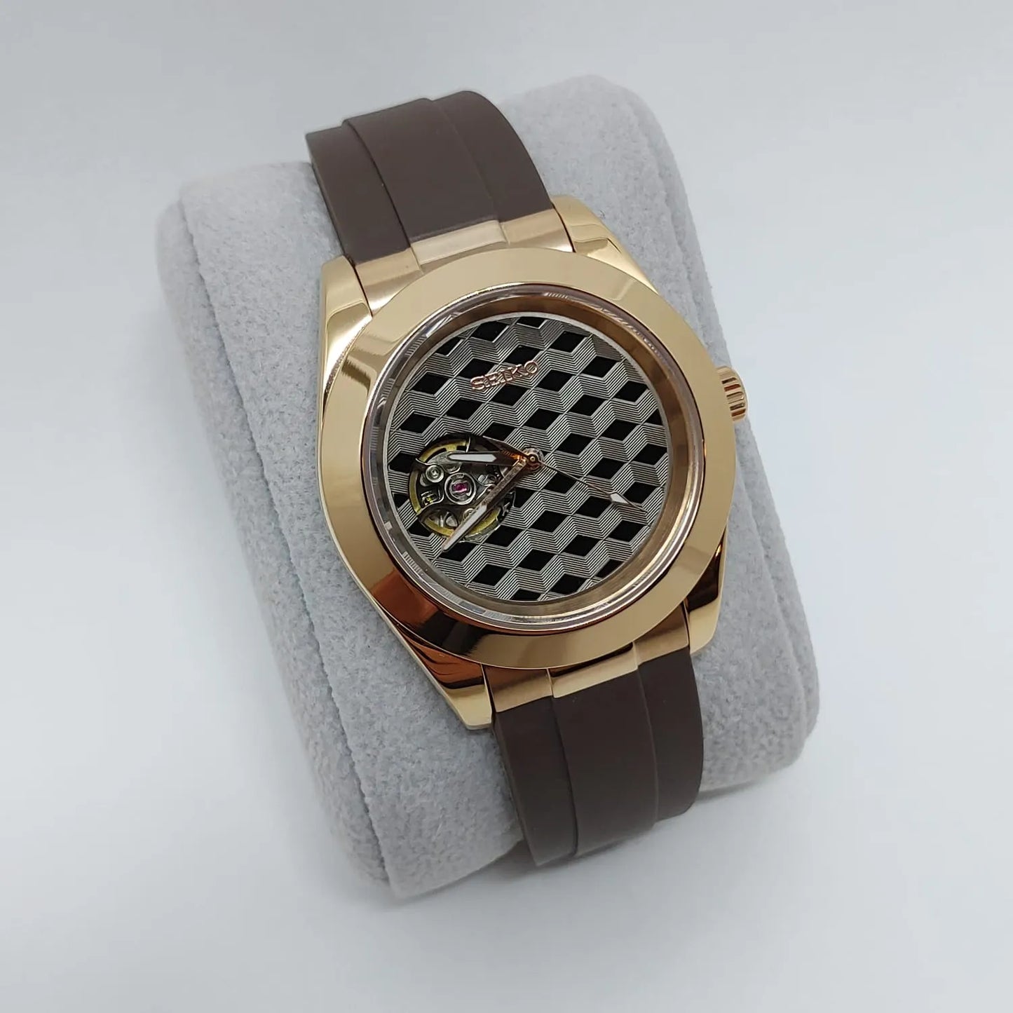 Gold-toned Seiko watch with brown leather strap and geometric guilloche dial featuring open heart design.