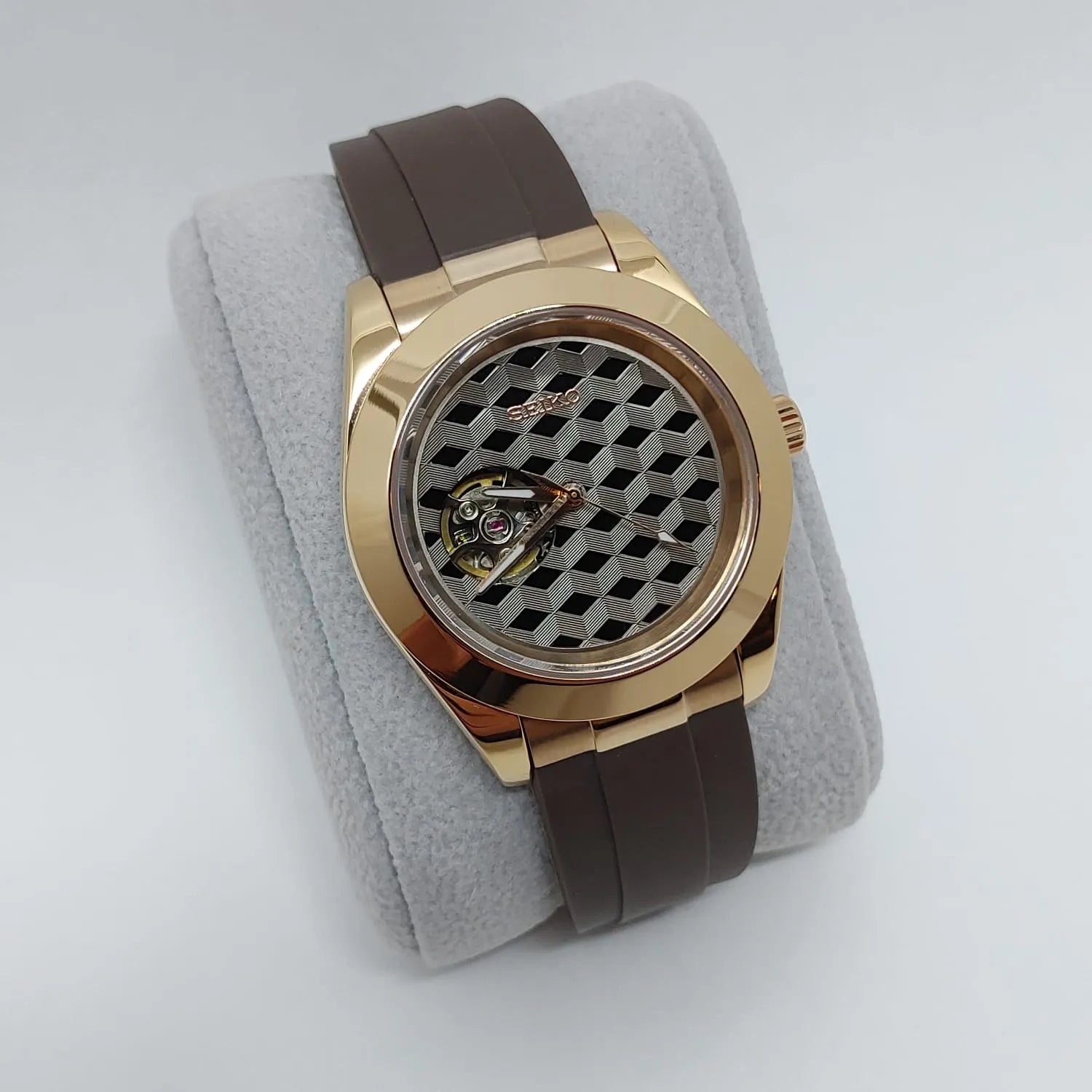 Gold-toned Seiko watch with brown leather strap and geometric guilloche dial featuring open heart design.