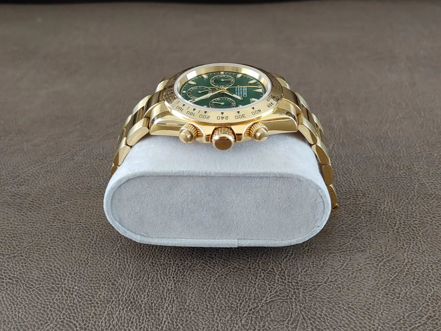 Gold stainless steel 40mm chronograph watch with green dial and gold link bracelet.