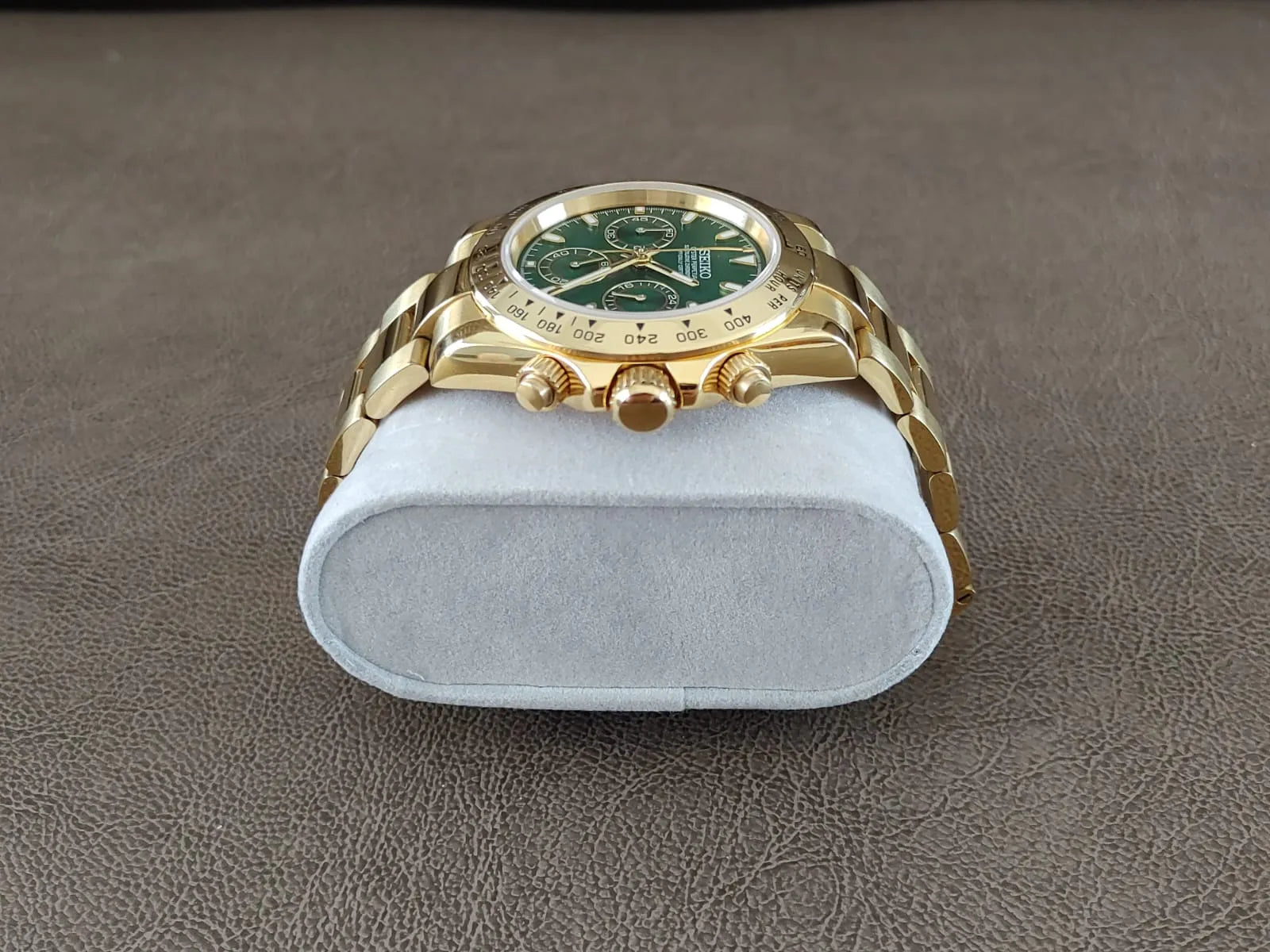 Gold stainless steel 40mm chronograph watch with green dial and gold link bracelet.