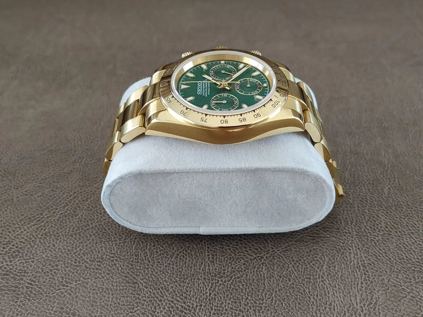 40mm gold stainless steel Seiko chronograph watch with green dial and three subdials on metal bracelet.