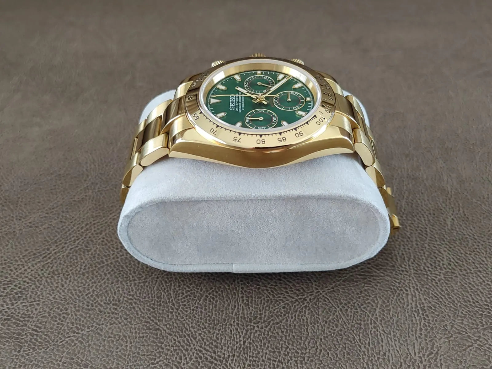 40mm gold stainless steel Seiko chronograph watch with green dial and three subdials on metal bracelet.