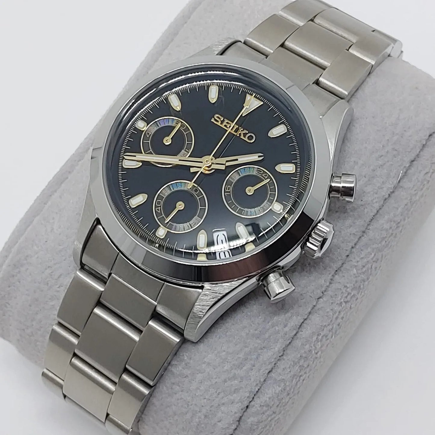 Seiko VK63 chronograph watch with black dial, gold accents, stainless steel case and bracelet, 37mm size.