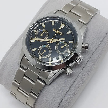 Seiko VK63 chronograph watch with black dial, gold accents, stainless steel case and bracelet, 37mm size.