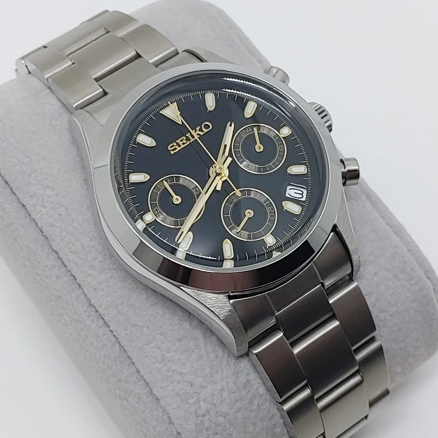 Seiko VK63 chronograph watch with black dial, gold-tone hands and markers, stainless steel case and bracelet, date window at