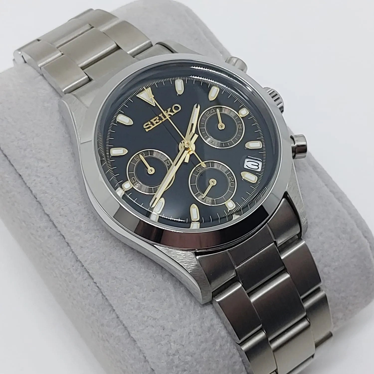 Seiko VK63 chronograph watch with black dial, gold-tone hands and markers, stainless steel case and bracelet, date window at