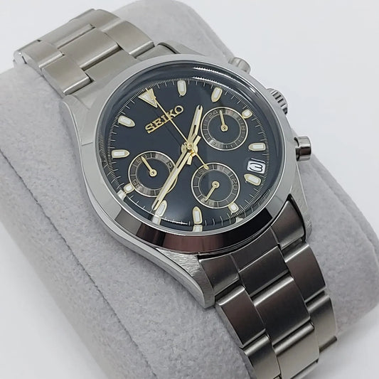 Seiko VK63 chronograph watch with black dial, gold-tone hands and markers, stainless steel case and bracelet, date window at