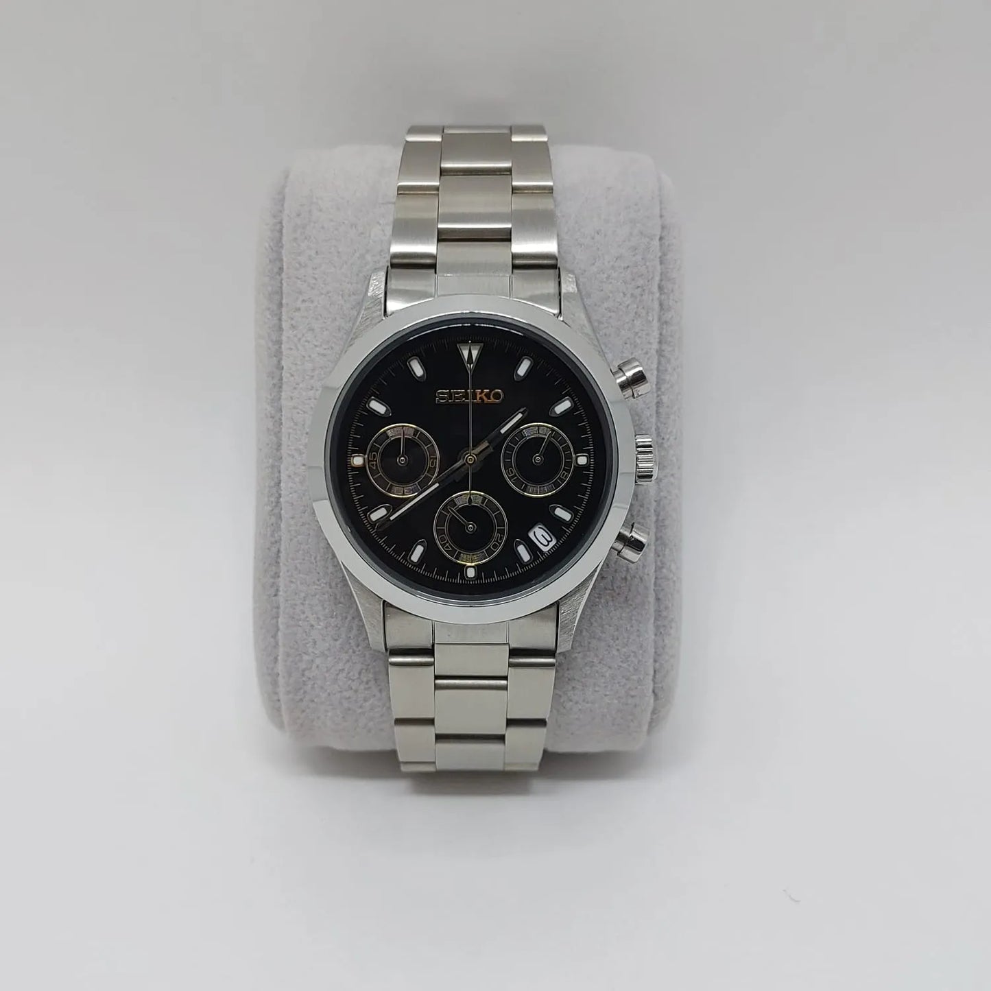 Stainless steel Seiko wristwatch with black dial, gold-tone subdials, and silver bracelet band.