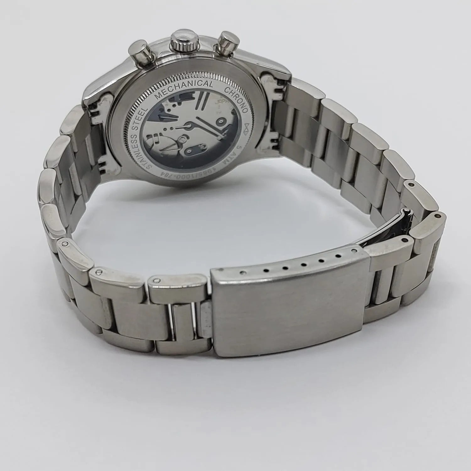 Seiko VK63 watch with stainless steel bracelet and open case back showing mechanical movement.