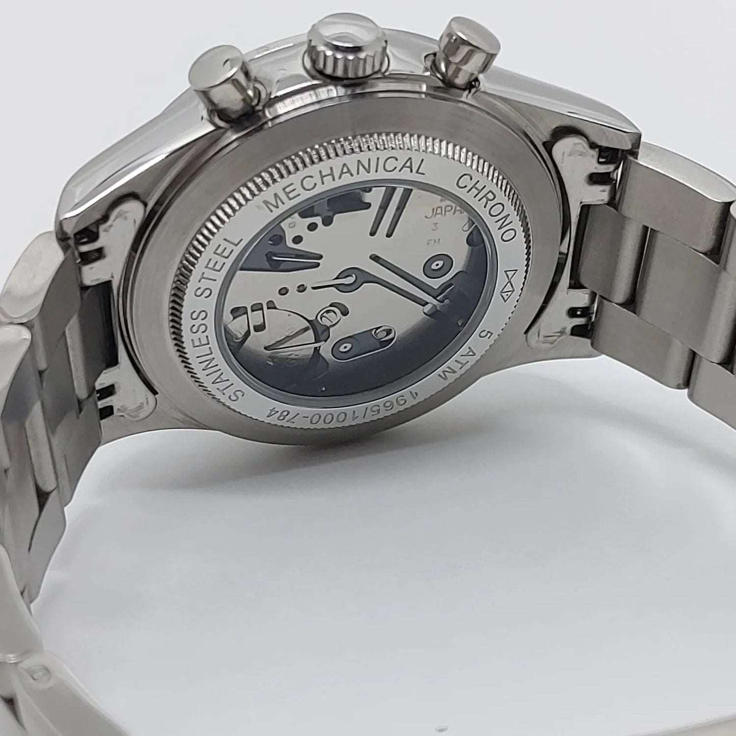 Seiko VK63 stainless steel watch case back with exhibition window showing mechanical chrono movement, linked metal bracelet.