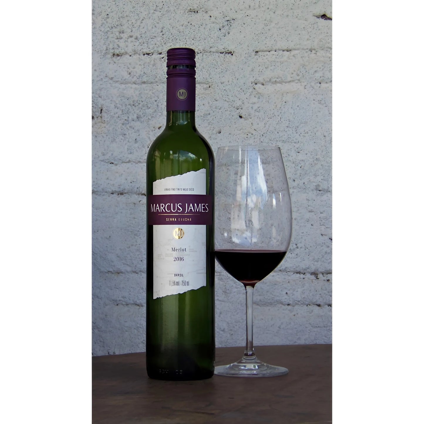 Marcus James Reserved Demi-Sec Merlot wine bottle with a filled wine glass against a white brick wall background.