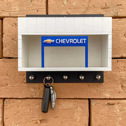 White and black Chevrolet wall-mounted key hook rack with blue and silver accents, holding two keys.