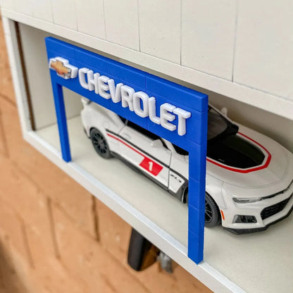 Blue Chevrolet wall key hook rack with silver hooks and white scale model car displayed inside.