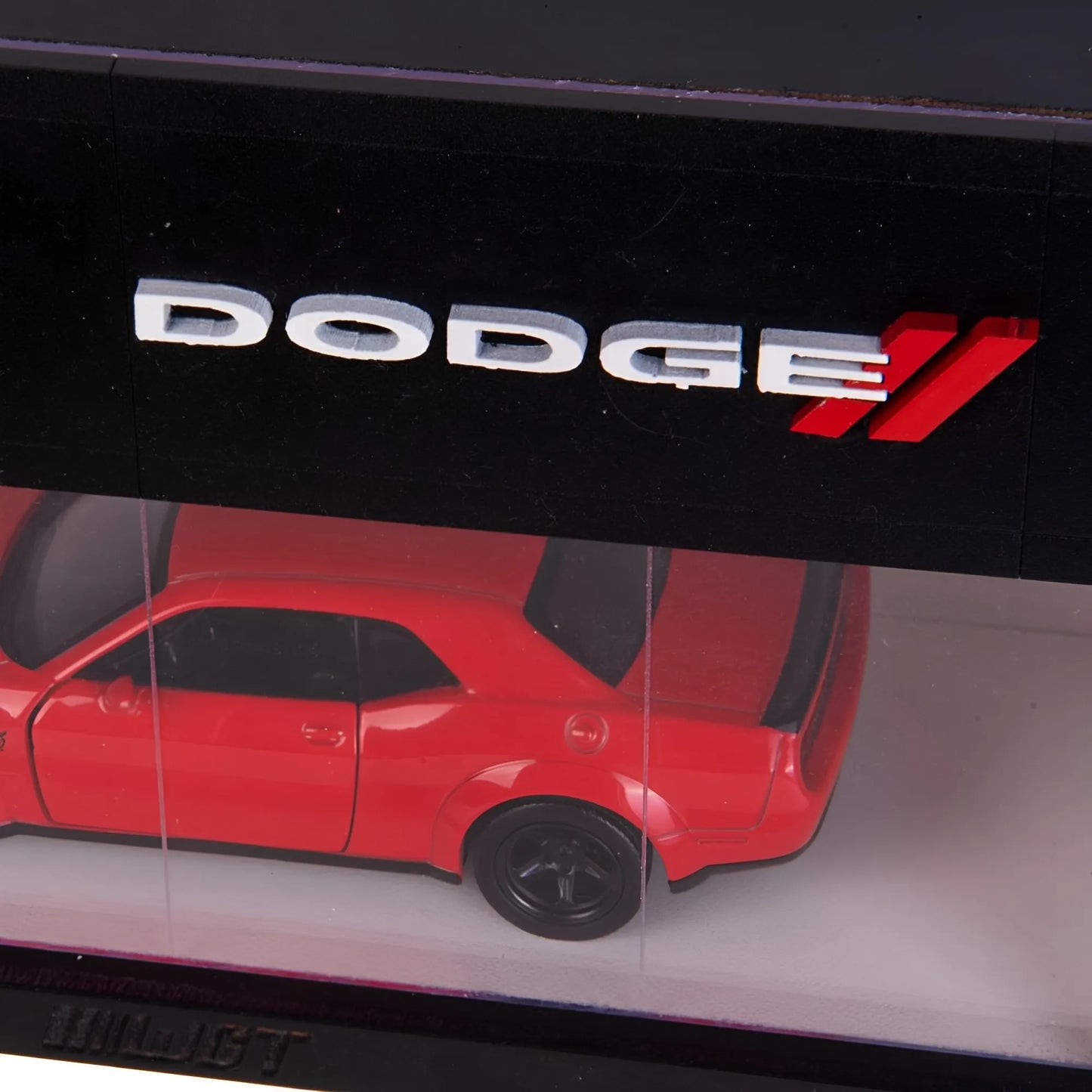Red scale model Dodge car displayed in a black wall-mounted case with silver Dodge logo above.