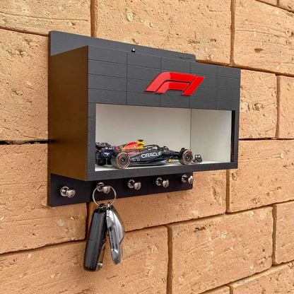 Black wall-mounted F1 key hook rack with red F1 logo and scale model race car display shelf.