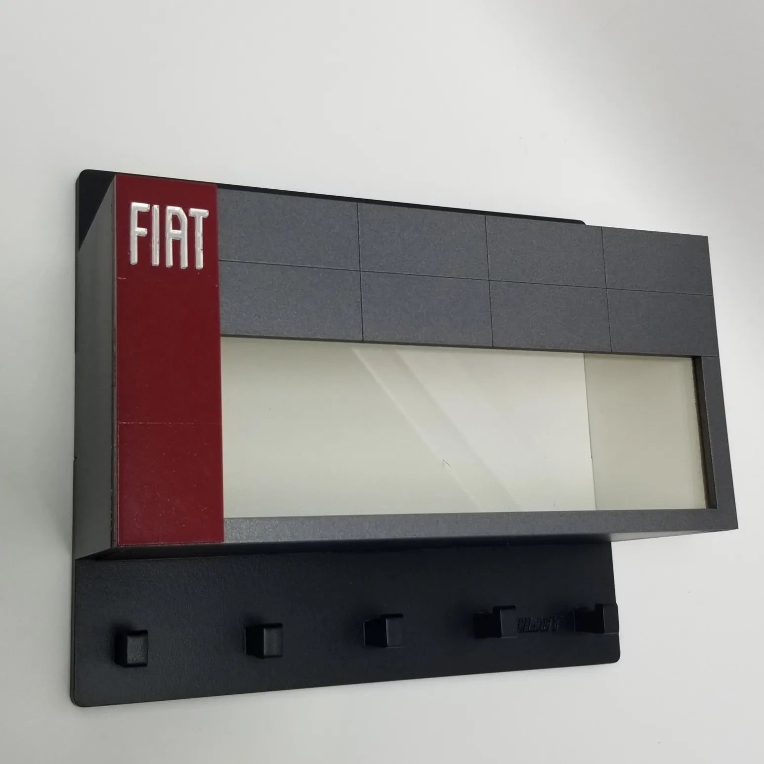 Black wall-mounted key hook rack with five hooks, featuring a gray and red panel with white Fiat logo on left side.