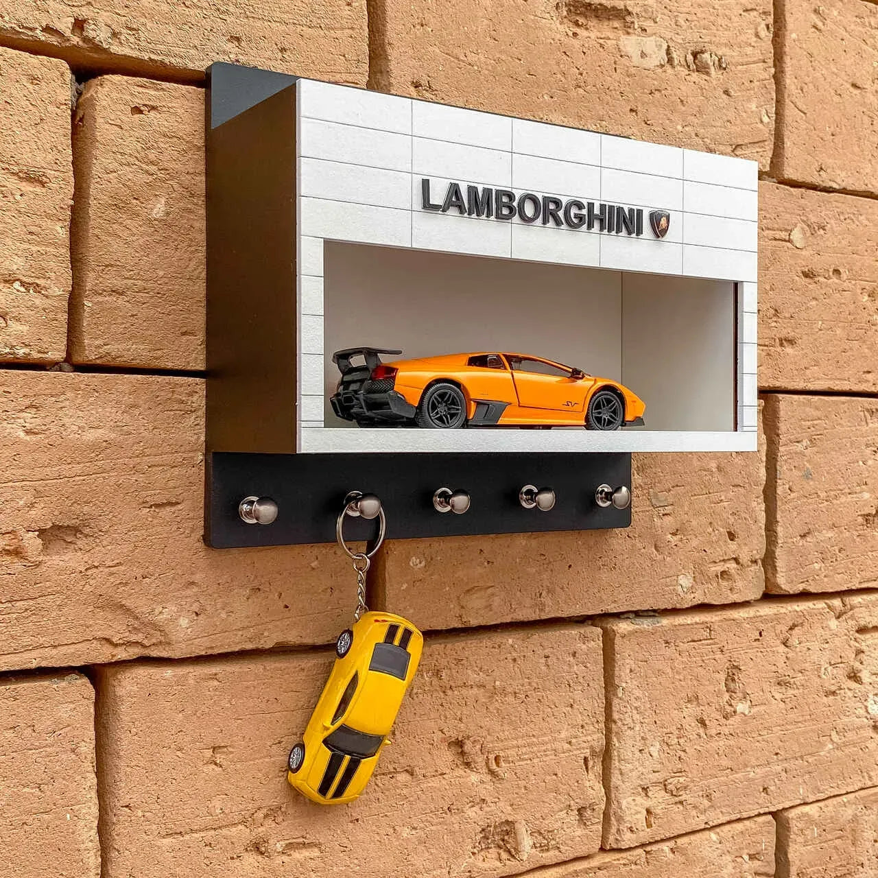 Orange Lamborghini scale model displayed inside a white and black wall-mounted key hook rack with six hooks and Lamborghini.