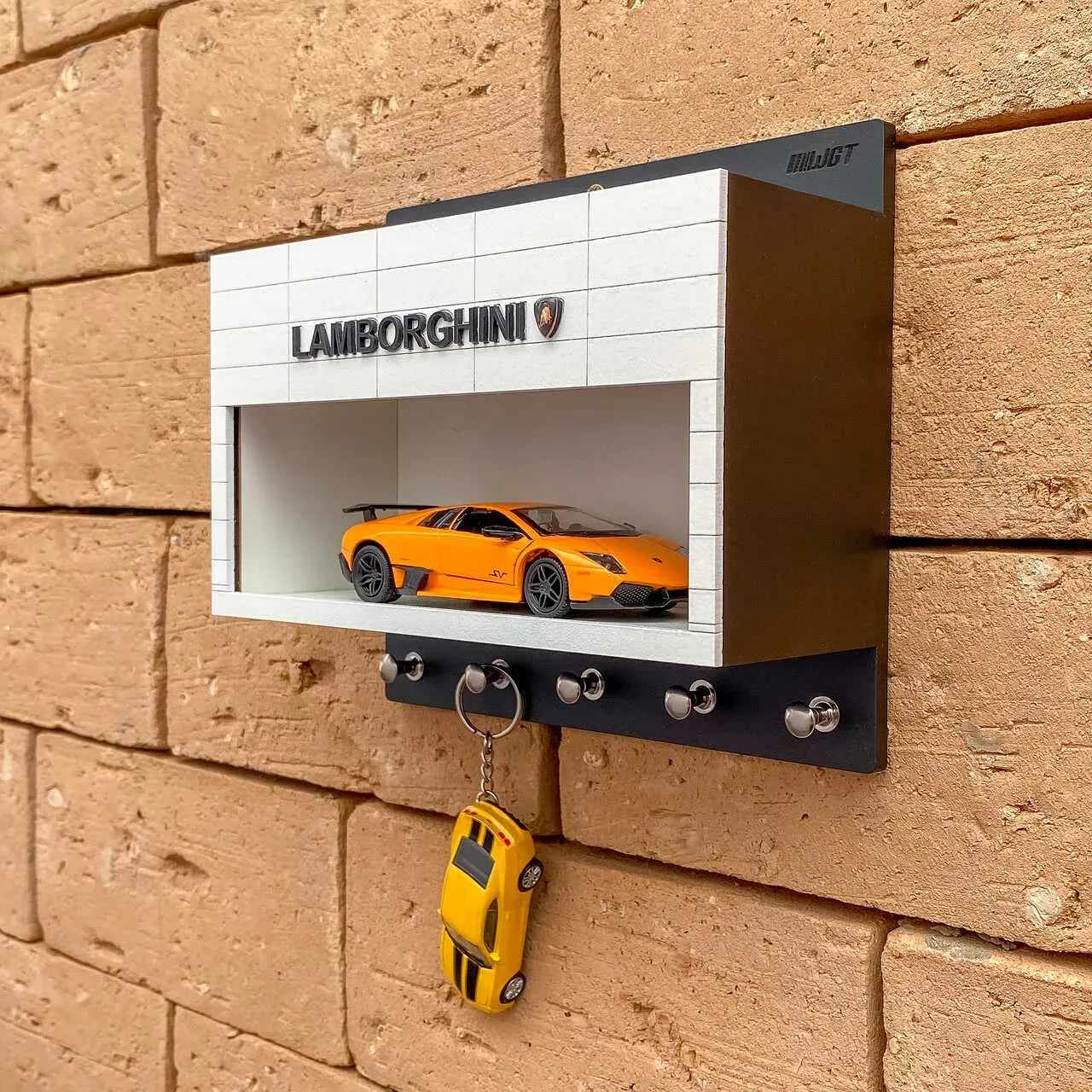Black and white Lamborghini wall-mounted key hook rack with orange scale model car and five metal hooks.
