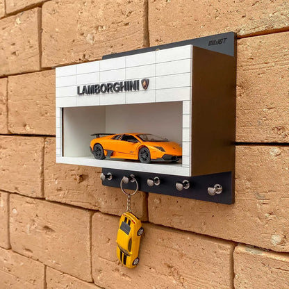 Black and white Lamborghini wall-mounted key hook rack with orange scale model car and five metal hooks.