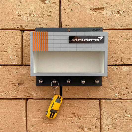 Gray McLaren-themed wall key hook rack with four metal hooks and a yellow sports car keychain hanging on one hook.