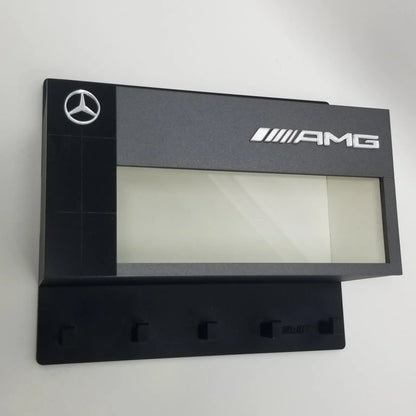 Black Mercedes AMG wall-mounted key hook rack with five hooks and logo panel above.