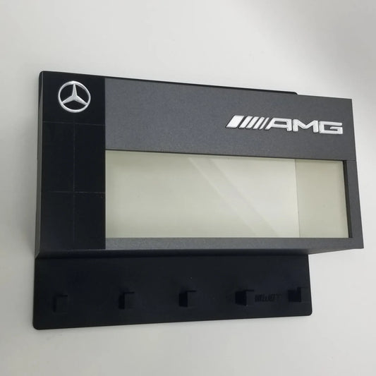 Black Mercedes AMG wall-mounted key hook rack with five hooks and logo panel above.