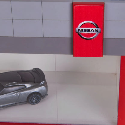 Red rectangular Nissan wall key hook rack with white Nissan logo and silver key hooks inside.