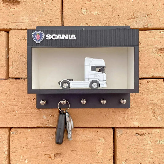 Black Scania wall key hook rack with white scale model truck and five metal hooks mounted on brick wall.