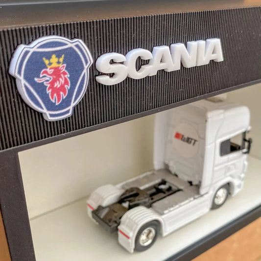 White scale model Scania truck displayed inside black wall-mounted key hook rack with Scania logo and emblem on top panel.