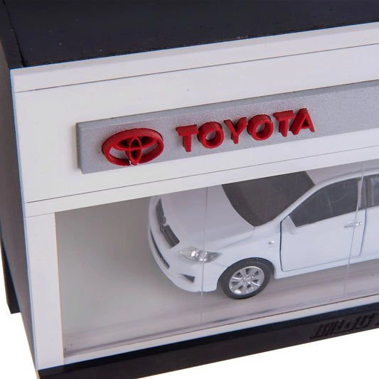 White Toyota scale model car inside clear display case with red Toyota logo and wall key hook rack.
