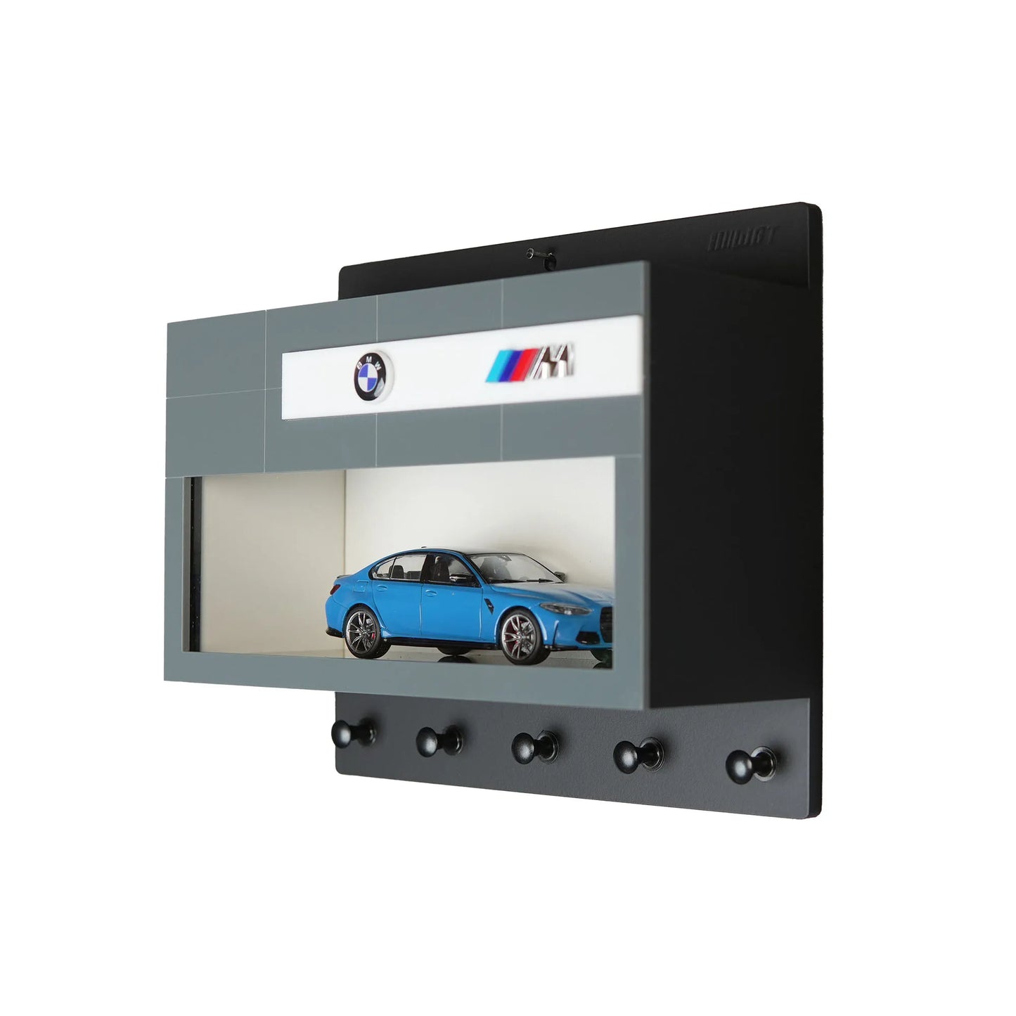 Black and gray wall-mounted key hook rack with five hooks and a blue BMW M scale model car displayed inside a clear-front.