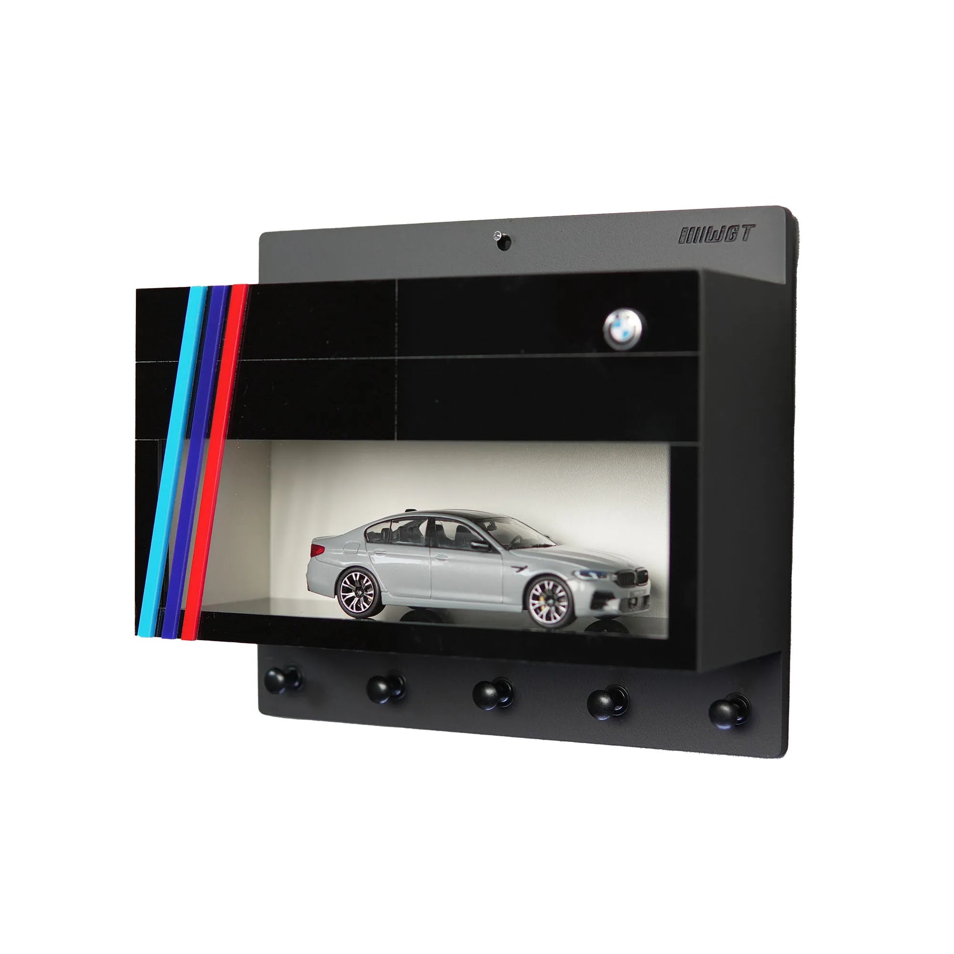Black wall-mounted key rack with four BMW logo hooks, built-in display case featuring silver BMW scale model, and decorative