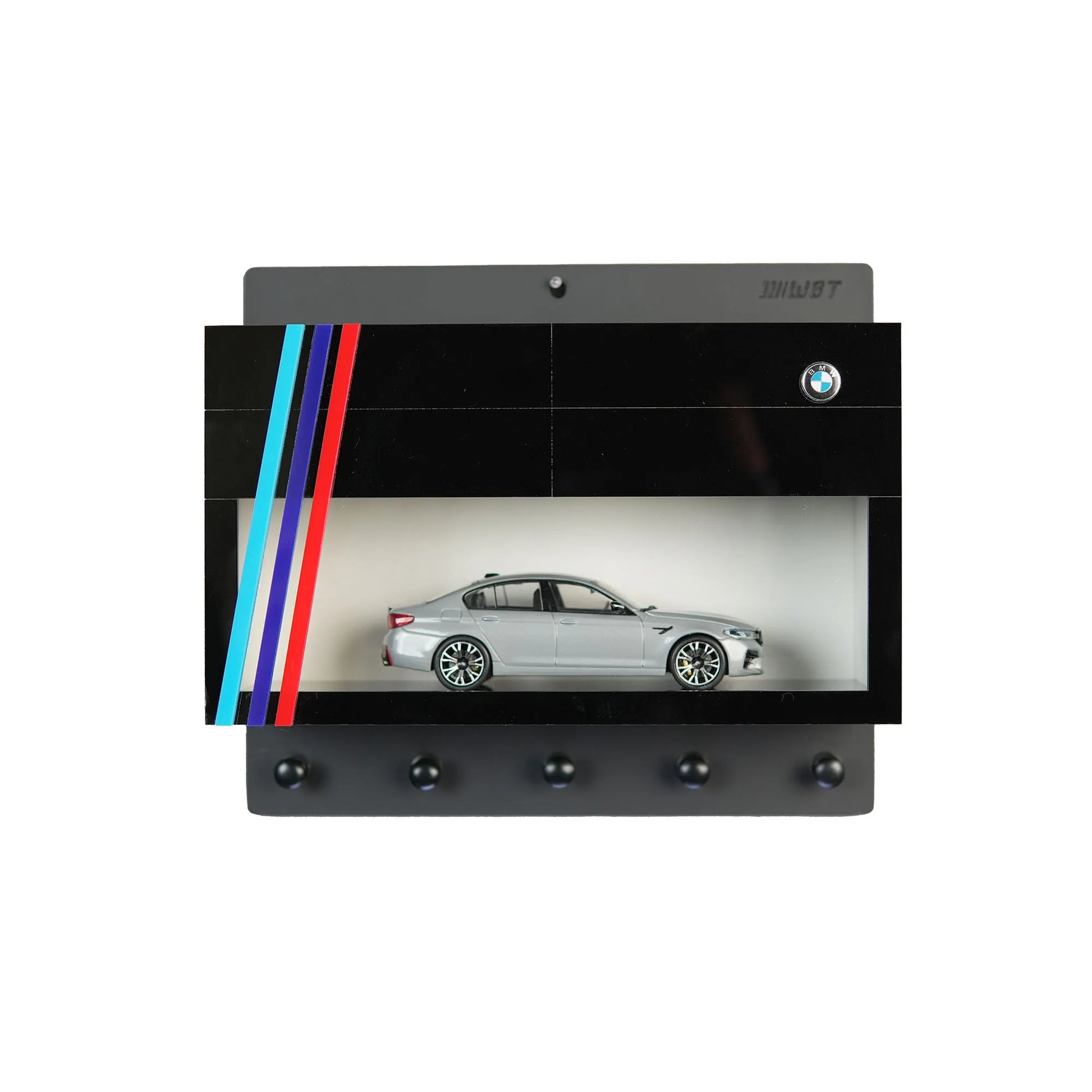 Black BMW wall-mounted key hook rack with red, blue, and light blue stripes and silver scale model car display case.