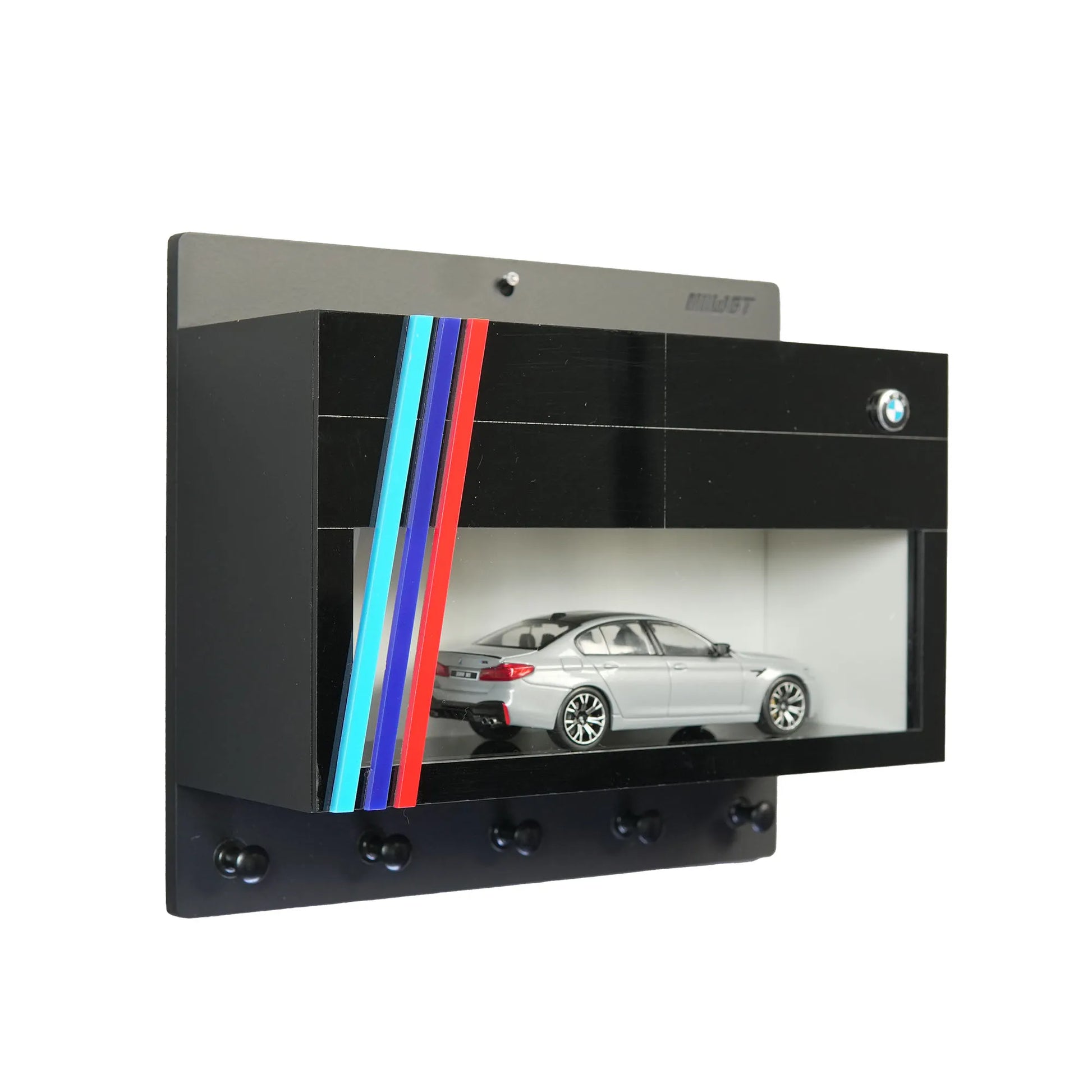Black BMW wall-mounted key hook rack with glass display case featuring a silver model car and colorful stripe accents.