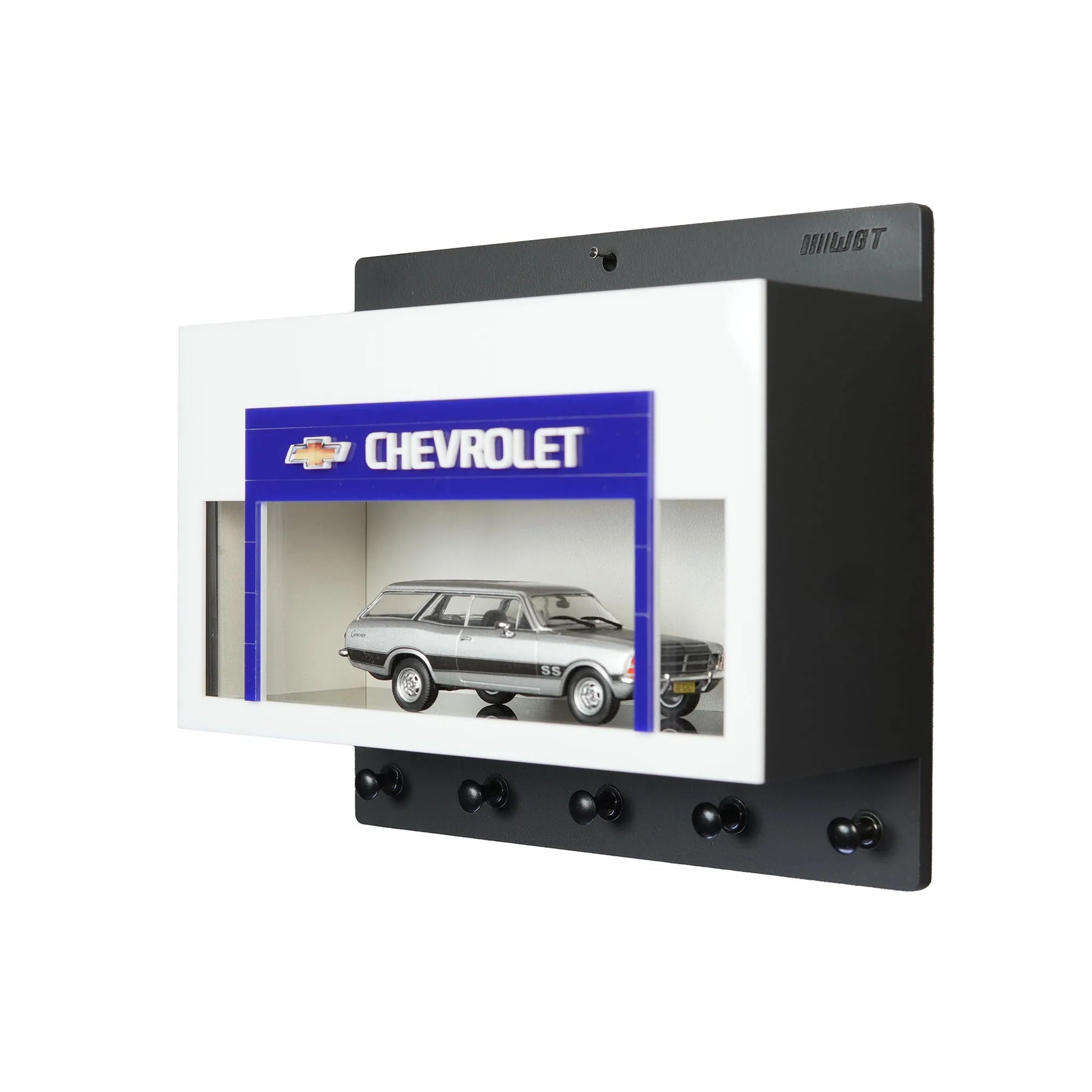 Black and white Chevrolet wall key hook rack with scale model car display featuring a silver station wagon model and four.