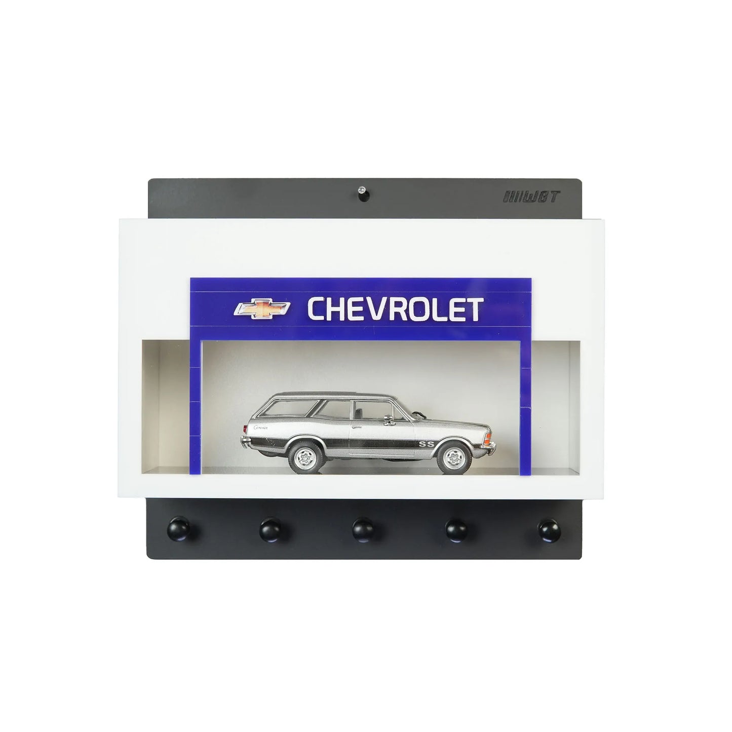White wall key hook rack with a built-in display case featuring a silver scale model Chevrolet station wagon and five black.