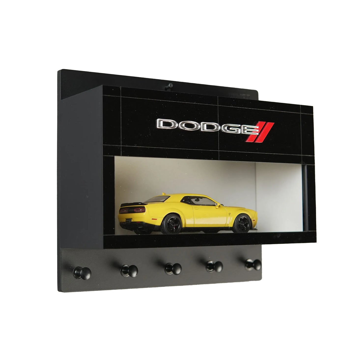Black wall-mounted key hook rack with Dodge logo and yellow scale model car display shelf.
