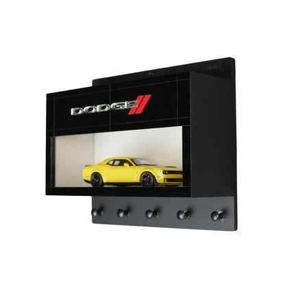 Black Dodge wall key hook rack with glass display case featuring a yellow scale model car and four hooks.