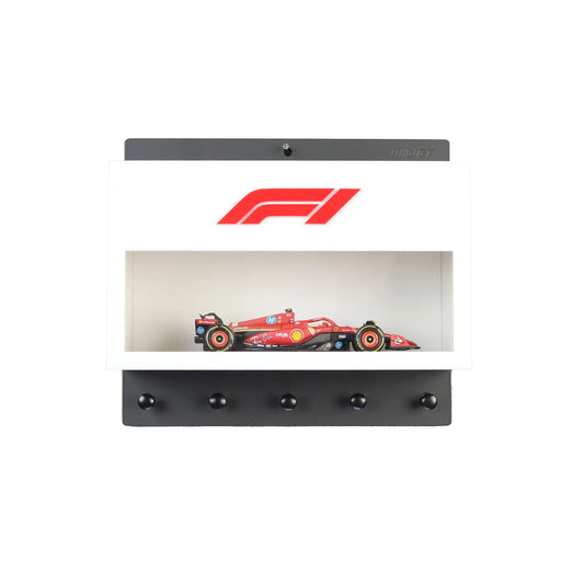 White wall-mounted key hook rack with clear display case holding red Formula One model car and five black hooks below.