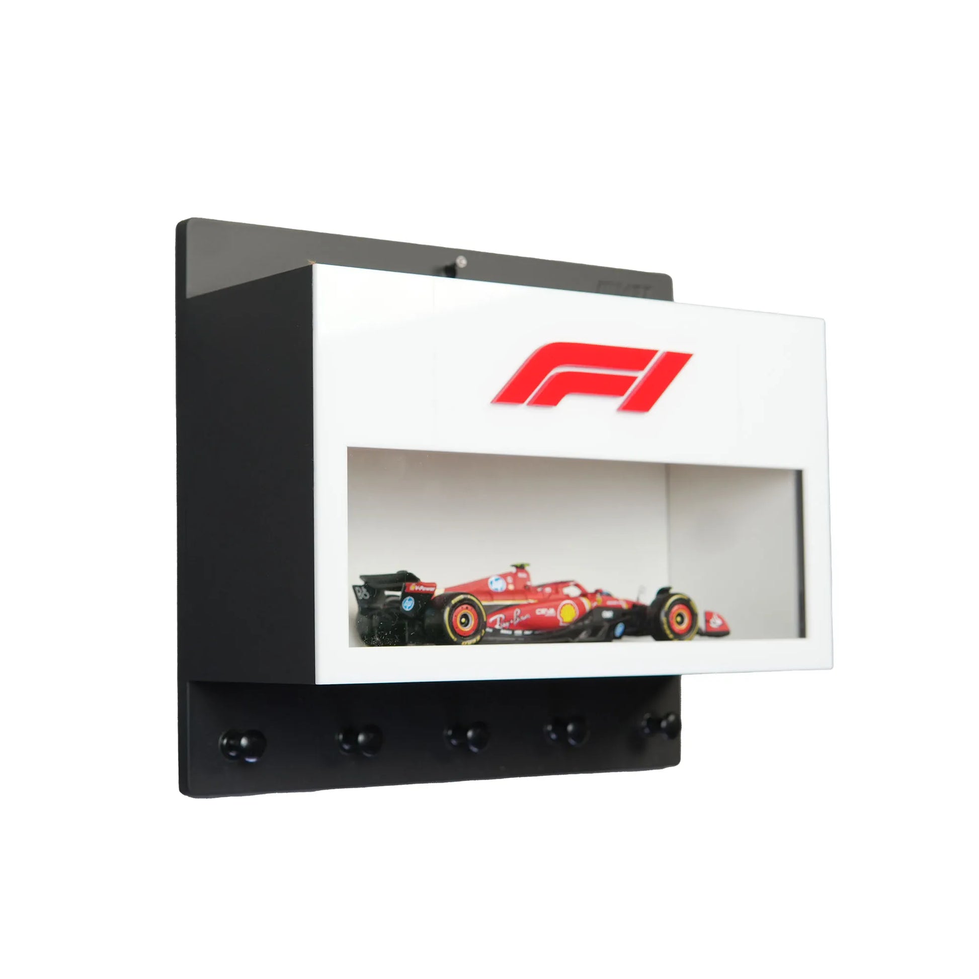 White wall-mounted key hook rack with F1 logo and red Formula One car display case.