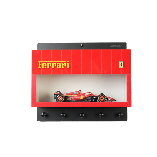 Red Ferrari wall-mounted key hook rack with four black hooks and a small red Ferrari race car model inside a display case.