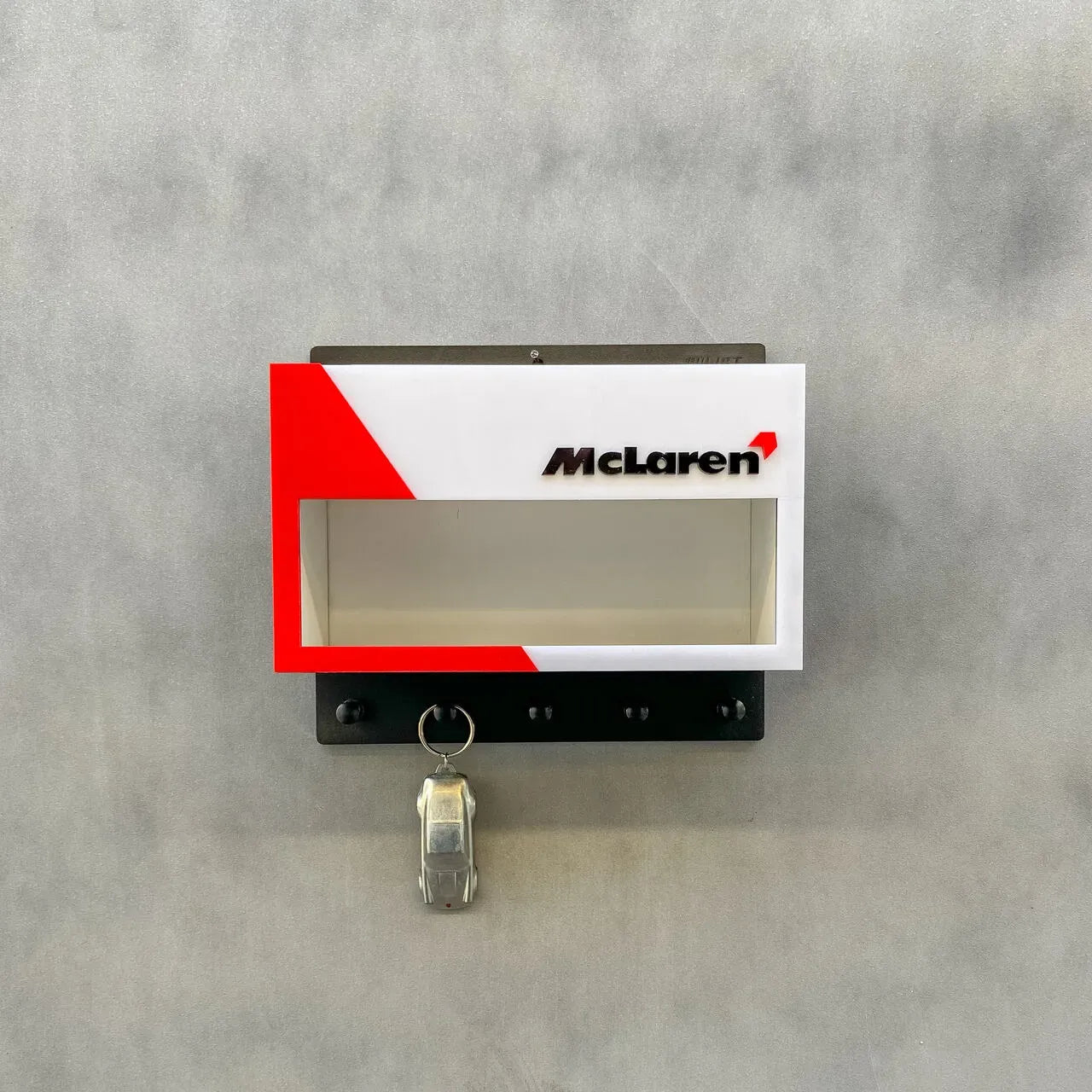 White and red McLaren-themed wall key hook rack with a clear display case and three metal hooks.