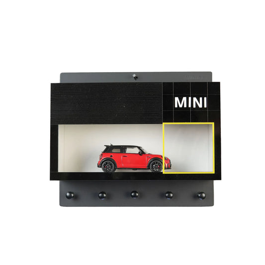 Black wall-mounted key rack with five hooks and built-in display case holding a red Mini Cooper model car.