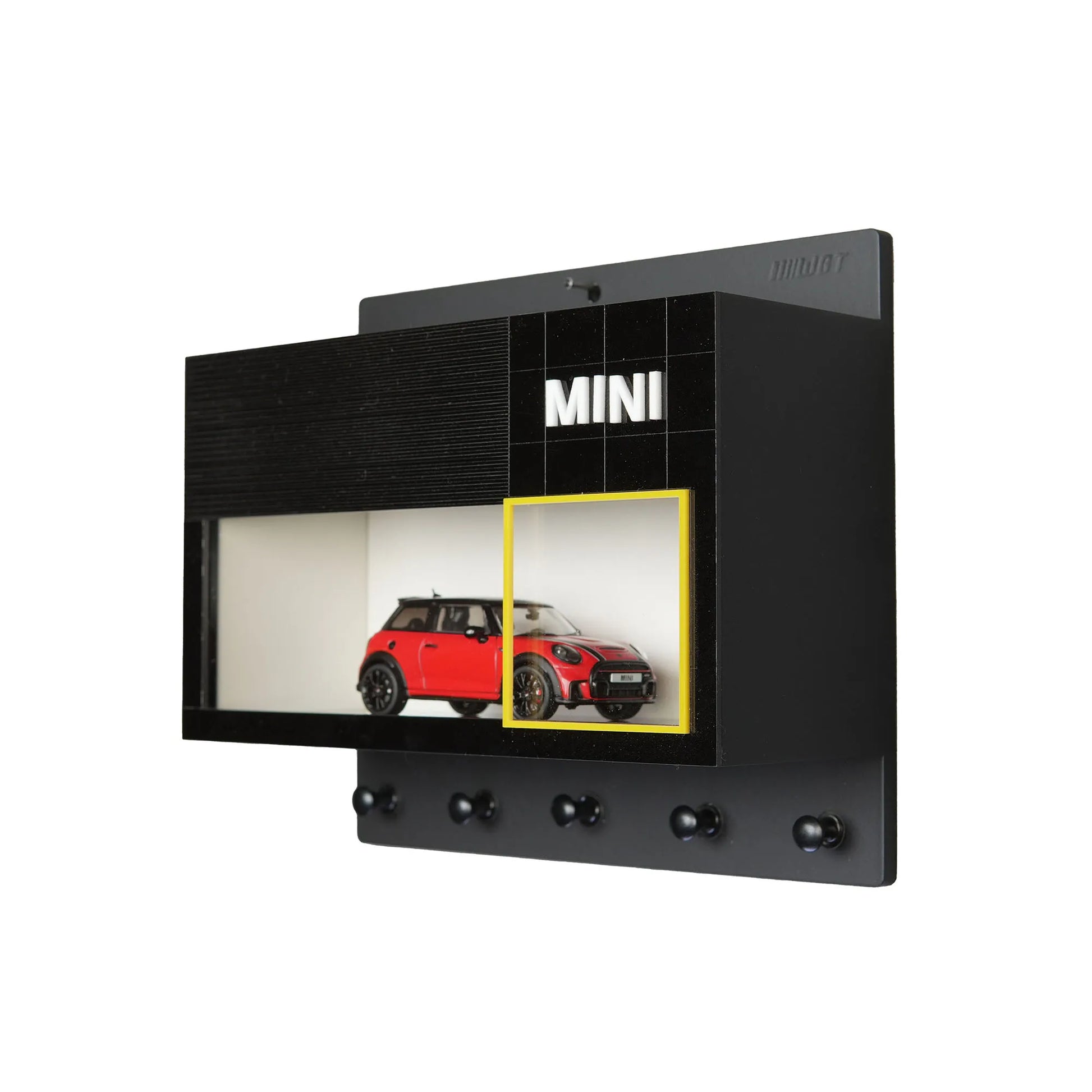 Black wall-mounted key hook rack with small display case featuring a red Mini Cooper model car.