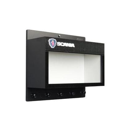 Black wall-mounted key hook rack with Scania logo and transparent display case window.