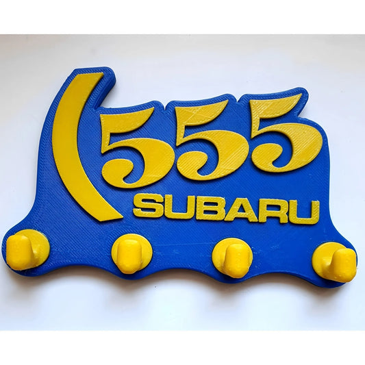 Blue and yellow Subaru 555 wall key hook rack with four rounded hooks.